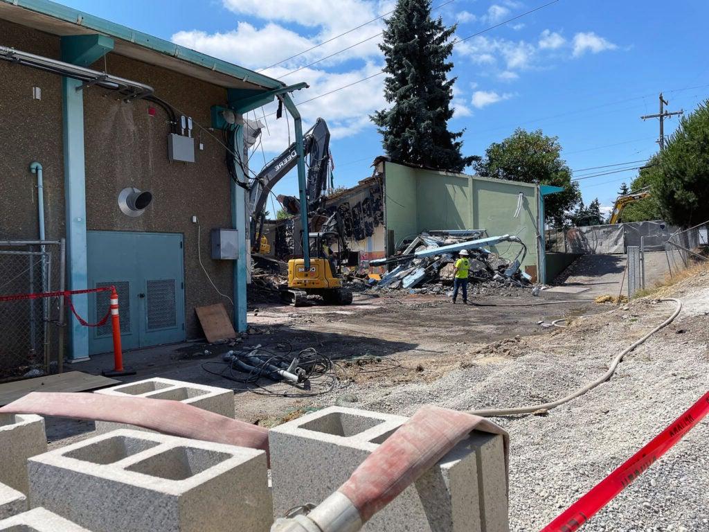 an excavator is demolishing a building